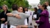 Neda Shargi, saudara perempuan tahanan Iran Emad Shargi, memeluk mantan sandera Suriah Sam Goodwin sebelum konferensi pers dengan keluarga orang Amerika yang ditahan di luar negeri di Lafayette Park dekat Gedung Putih, 4 Mei 2022, di Washington. (Foto: AP)