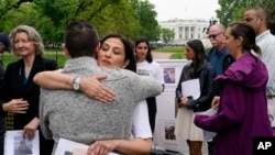 Neda Shargi, saudara perempuan tahanan Iran Emad Shargi, memeluk mantan sandera Suriah Sam Goodwin sebelum konferensi pers dengan keluarga orang Amerika yang ditahan di luar negeri di Lafayette Park dekat Gedung Putih, 4 Mei 2022, di Washington. (Foto: AP)