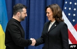 FILE - Presiden Ukraina Volodymyr Zelensky dan Wakil Presiden AS Kamala Harris berjabat tangan di akhir konferensi pers di Konferensi Keamanan Munich (MSC) di Munich, Jerman selatan, 17 Februari 2024. (Tobias SCHWARZ / POOL / AFP)