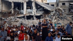 Palestinians hold Eid al-Adha prayers by the ruins of the Al-Rahma mosque destroyed by Israeli airstrikes, amid the Israel-Hamas conflict, in Khan Younis, in the southern Gaza Strip, June 16, 2024. 