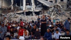 Warga Palestina menggelar salat Idul Adha di dekat reruntuhan masjid Al-Rahma yang hancur akibat serangan udara Israel, di tengah konflik Israel-Hamas, di Khan Younis, di Jalur Gaza selatan, Minggu 16 Juni 2024.