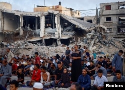 Warga Palestina melakukan salat Idul Adha di dekat reruntuhan masjid Al-Rahma yang hancur akibat serangan udara Israel di kota Khan Younis, Jalur Gaza selatan, 16 Juni 2024.