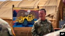 FILE - Major General Kenneth Ekman speaks in front of a "Welcome to Niamey" sign depicting U.S. military vehicles at Air Base 101 in Niger, May 30, 2024. (U.S. Air Force via AP)
