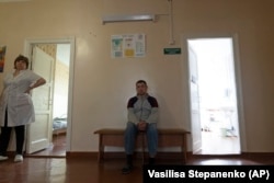 Oleksandr, a patient, sits in a corridor at a psychiatric hospital In Kramatorsk, Ukraine, Tuesday March 21, 2023. (AP Photo/Vasilisa Stepanenko)