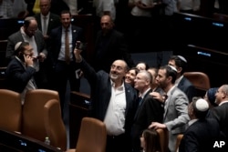 Israeli lawmakers celebrate by taking a selfie after approving a key portion of Prime Minister Benjamin Netanyahu's divisive plan to reshape the country's justice system, on the floor of the Knesset, Israel's parliament, in Jerusalem, July 24, 2023.