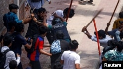 A police officer is beaten by mob during a clash between anti-quota supporters, police and Awami League supporters at the Rampura area in Dhaka, Bangladesh, July 18, 2024.