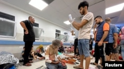 FILE - Palestinians who were wounded after a convoy of ambulances was hit, are assisted at Shifa hospital in Gaza City, Nov. 3, 2023.