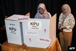 Pendukung calon presiden Anies Baswedan dan calon wakil presiden Muhaimin Iskandar mencoba melakukan simulasi pemungutan suara dalam kampanye yang diselenggarakan oleh relawan pemuda di Jakarta pada 8 Februari 2024. (Foto: AFP)