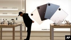 A customer looks at the products displayed at a Huawei flagship store in Beijing, China, March 23, 2023. in 2020, the U.S. accuses Huawei of stealing trade secret from six U.S. companies. (AP/Ng Han Guan)