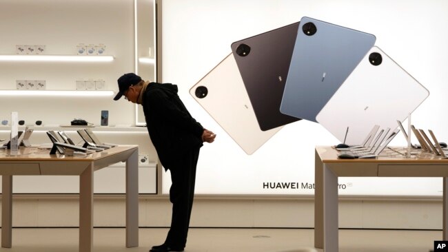 A customer looks at the products displayed at a Huawei flagship store in Beijing, China, March 23, 2023. in 2020, the U.S. accuses Huawei of stealing trade secret from six U.S. companies. (AP/Ng Han Guan)