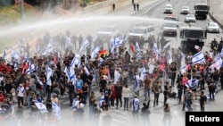 Police use a water canon as demonstrators take part in the Day of Shutdown, as Israeli Prime Minister Benjamin Netanyahu's nationalist coalition government presses on with its judicial overhaul, in Tel Aviv, Israel, March 23, 2023. 