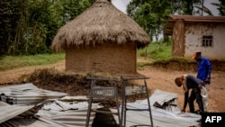 People visit the Mukondi health center burned during an attack attributed to the ADF in Mukondi, about 30 kilometers from the town of Beni in eastern Democratic Republic of Congo, on March 10, 2023.