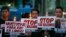 FILE - Para pengunjuk rasa memegang plakat sambil menyalakan lilin dalam protes menentang "pembunuhan di luar hukum" terhadap kampanye "Perang Antinarkoba" oleh Presiden Rodrigo Duterte di pinggiran kota Quezon, timur laut Manila, Filipina 8 Oktober 2016 (foto: dok).