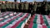 FILE - Revolutionary Guard members stand over the flag-draped coffins of victims a bomb explosion during their funeral ceremony in the city of Kerman, Iran, Jan. 5, 2024. The Iranian government linked the attack to ethnic-Tajik fighters of the Islamic State Khorasan Province.
