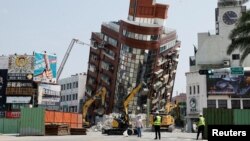 Para petugas melakukan operasi pencarian korban di lokasi runtuhnya bangunan, menyusul gempa bumi di Hualien, Taiwan, 4 April 2024. (REUTERS/Carlos Garcia Rawlins)