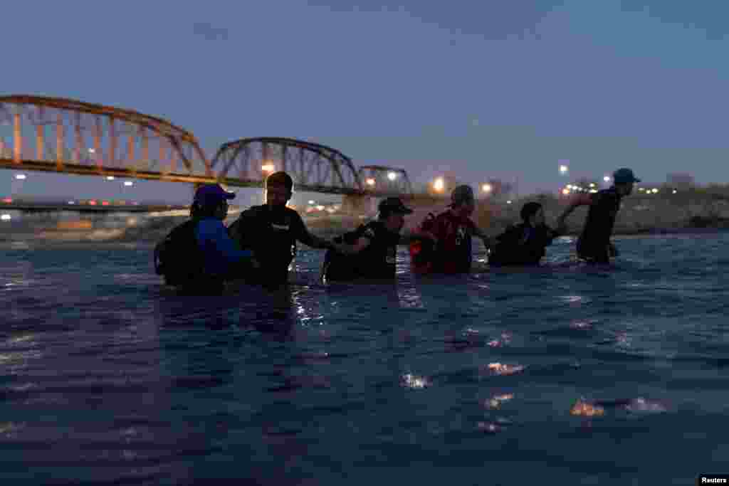 Migrants wade through the Rio Grande River to cross into Eagle Pass, Texas, U.S., in Piedras Negras, Coahuila, Mexico, Feb. 24, 2024.