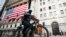 FILE - Seorang pekerja pengiriman barang mengendarai sepeda listriknya melewati New York Stock Exchange di New York, 16 Maret 2020. (AP/John Minchillo, File)