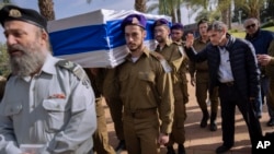 Yoram, right, father of Israeli soldier Lt. Yaacov Elian, bids farewell as soldiers carry his son's flag-draped casket during his funeral at Kiryat Shaul military cemetery in Tel Aviv, Israel, Dec. 22, 2023.