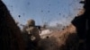 A Ukrainian soldier of the 28th Brigade fires a grenade launcher on the front line during a battle with Russian troops near Bakhmut, Donetsk region, Ukraine, March 24, 2023.