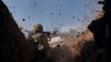 A Ukrainian soldier of the 28th Brigade fires a grenade launcher on the front line during a battle with Russian troops near Bakhmut, Donetsk region, Ukraine, March 24, 2023.