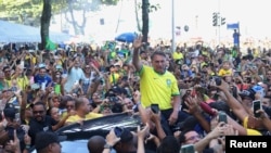 Mantan Presiden Brazil Jair Bolsonaro menyapa para pendukungnya yang hadir dalam aksi unjur rasa di Copacabana, Rio de Janeiro, pada 21 April 2024. (Foto: Reuters/Pilar Olivares)