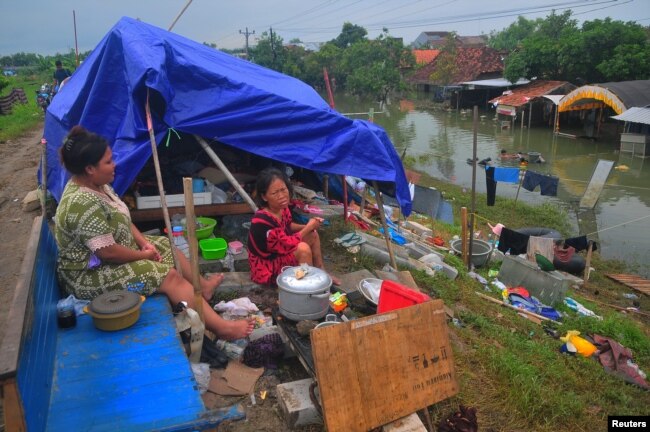 Masyarakat beristirahat di tenda darurat seiring ditundanya pemungutan suara pemilu di 10 desa di Kabupaten Karanganyar yang terdampak banjir Sungai Wulan, di Demak, Jawa Tengah, Indonesia 14 Februari 2024. (Antara Foto/Yusuf Nugroho via REUTERS)