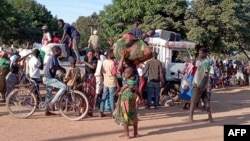 Displaced people from the region of Chiure, Mozambique, gather on Oct. 24, 2022, around a flat bed truck carrying mattresses and other household items salvaged by fleeing residents after a wave of incursions by armed groups. 