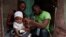 A local health worker measures the arm circumference of a 6-month-old girl who is suffering from malnutrition in Port-au-Prince, Haiti, July 13, 2023.