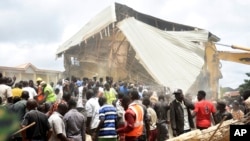 People and rescuers gather at the scene of a collapsed two-storey building in Jos, Nigeria, July, 12, 2024.