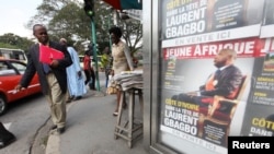 FILE - A man looks at posters of weekly news magazine Jeune Afrique in the business area of Abidjan, Ivory Coast, December 21, 2010. 