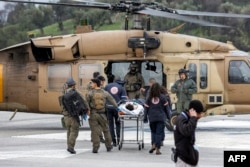 An Israeli medical team transports a person hurt in a rocket attack fired from southern Lebanon at Ziv hospital in Safed, Israel, Feb. 14, 2024, amid cross-border tensions as fighting continues between Israel and Hamas militants in the Gaza Strip.