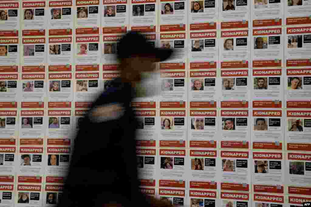 worker walks past &quot;Kidnapped&quot; fliers, displayed as members of the U.S. House of Representatives arrive to view graphic footage from the Oct. 7, 2023, Hamas attack in Israel, shown by the U.S. House Foreign Affairs Committee, on Capitol Hill. (Photo by Stefani Reynolds / AFP)