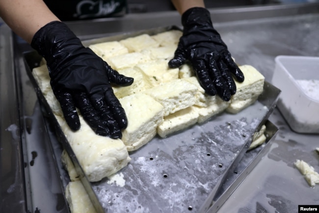 A worker prepares halloumi on Pantelis Panteli's farm in Kokkinotrimithia, Cyprus February 10, 2024. (REUTERS/Yiannis Kourtoglou)