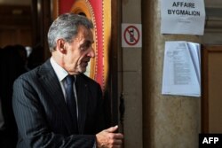 Mantan presiden Prancis Nicolas Sarkozy keluar setelah putusan dalam sidang banding dalam kasus Bygmalion, di gedung pengadilan, di Paris, pada 14 Februari 2024. (Bertrand GUAY / AFP)