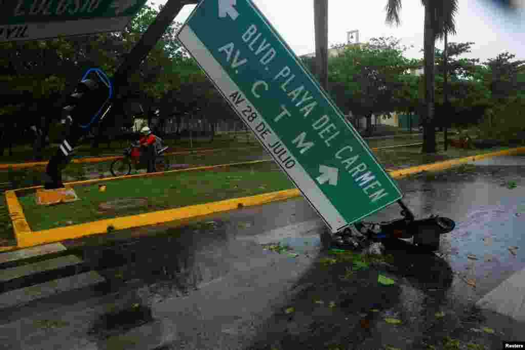 Un motorista pasa junto a un semáforo derribado por los fuertes vientos y lluvias causados por el huracán Beryl en Playa del Carmen, México.