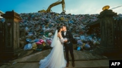 FILE - Iris Hsueh (L) and Ian Ciou have a picture taken on October 14, 2023, at a garbage dump in Puli Township, Taiwan. The bride is serious about the environment and wants to make a statement with her wedding photos. (Photo by Handout/OWEN KANG/AFP)