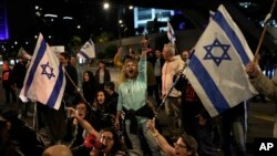 FILE - Protesters try to block a street during a demonstration to demand the release of the hostages taken by Hamas militants into the Gaza Strip during the October 7 attack, in Tel Aviv, Israel, Jan. 20, 2024.