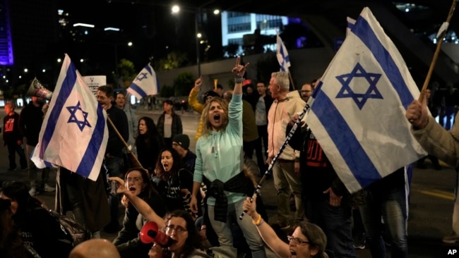 FILE - Protesters try to block a street during a demonstration to demand the release of the hostages taken by Hamas militants into the Gaza Strip during the October 7 attack, in Tel Aviv, Israel, Jan. 20, 2024.