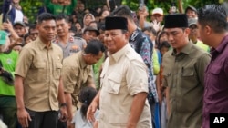 Prabowo Subianto, center, arrives for a visit to his father's grave in Jakarta, Indonesia, Feb. 15, 2024. The ex-general and current defense minister looks set to be the country's next president, according to unofficial vote tallies.