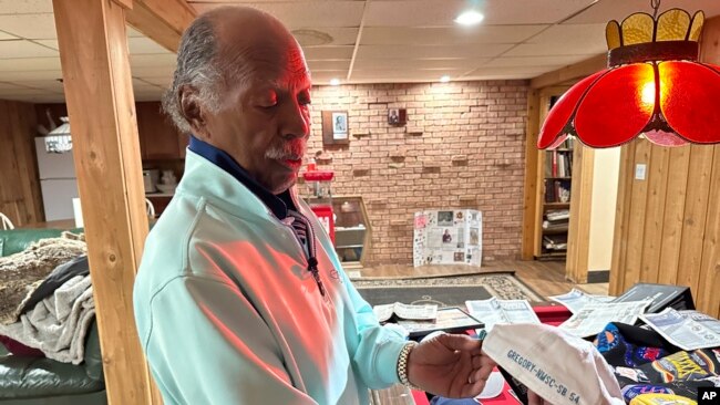 Gregory Eaton holds a commemorative Super Bowl hat with his name on it at his home, in Lansing, Michigan, Jan. 30, 2024.