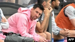 Lionel Messi, left, sits on the bench during a friendly football match between Hong Kong XI and U.S. Inter Miami CF in Hong Kong, Feb. 4, 2024.
