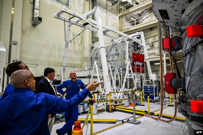 Astronot Jerman Badan Antariksa Eropa Alexander Gerst (kanan) melihat Modul Layanan Eropa untuk misi Artemis II, di dalam Gedung Operasi dan Pemeriksaan (O&C) di Kennedy Space Center, Cape Canaveral, Florida, 28 Agustus 2022. (CHANDAN KHANNA / AFP)