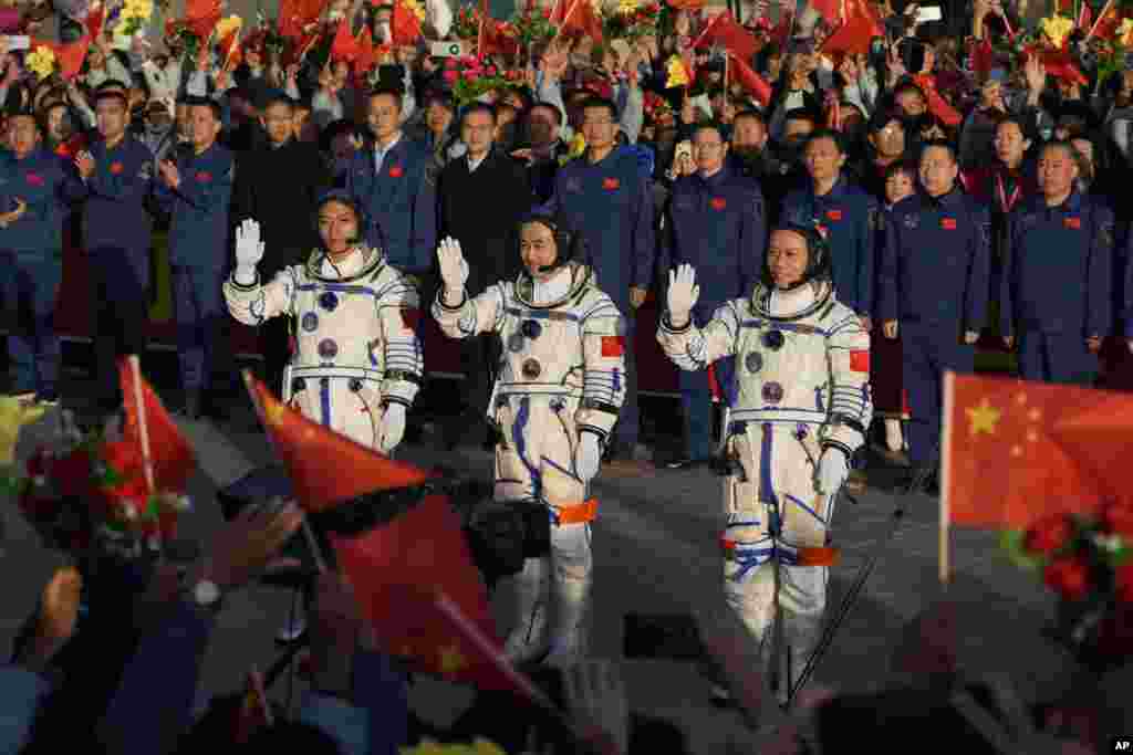 Chinese astronauts for the Shenzhou-17 mission, from left, Jiang Xinlin, Tang Hongbo and Tang Shengjie wave as they attend a send-off ceremony for their manned space mission at the Jiuquan Satellite Launch Center in northwestern China. (AP Photo/Andy Wong)