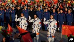 Chinese astronauts for the <em>Shenzhou-17</em> mission, from left, Jiang Xinlin, Tang Hongbo and Tang Shengjie wave as they attend a send-off ceremony for their manned space mission at the Jiuquan Satellite Launch Center in northwestern China.