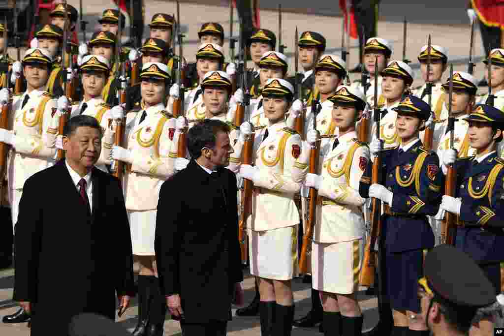 French President Emmanuel Macron, second from left, inspects an honor guard with Chinese President Xi Jinping outside the Great Hall of the People in Beijing.
