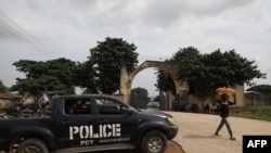 FILE - A police truck is stationed outside the University of Abuja Staff Quarters gate where unknown gunmen kidnapped people among whom were 2 of the university professors, lecturers and their family members in Abuja, Nigeria on November 2, 2021.