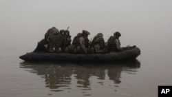 ARCHIVO - Marines ucranianos navegan a lo largo del río Dniéper en la línea del frente cerca de Jersón, Ucrania, el 14 de octubre de 2023.