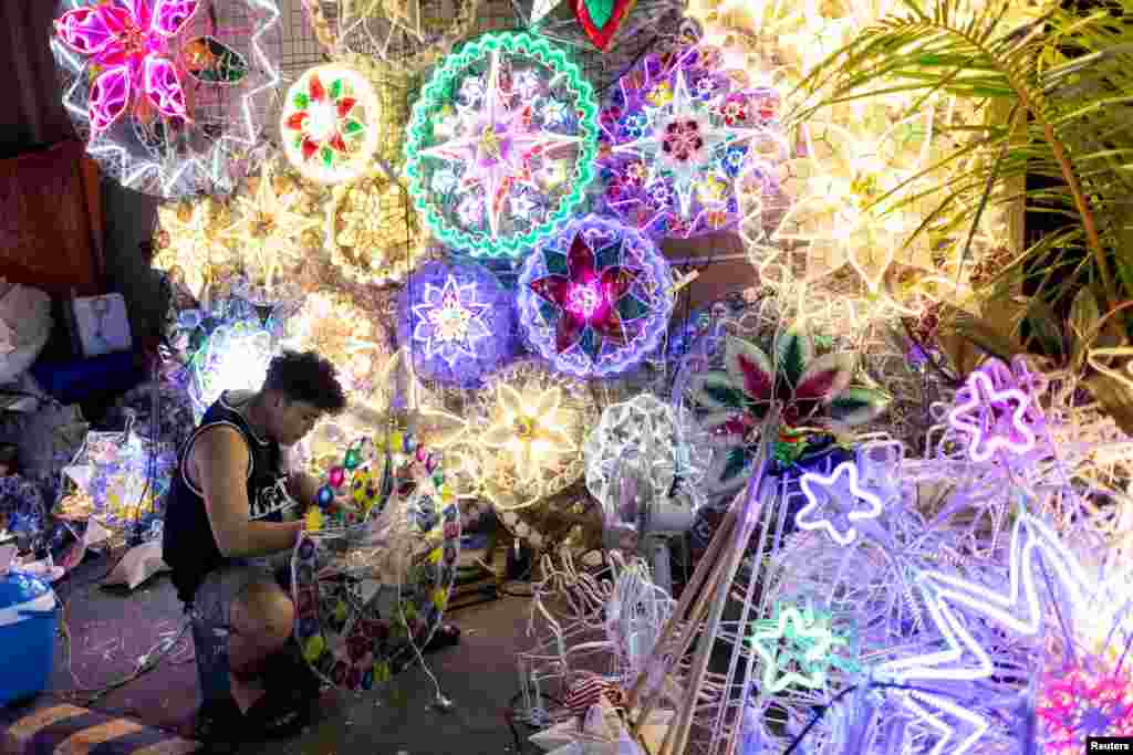 A vendor works on a Christmas star lantern, locally known as parol, at a street market in Quezon City, Metro Manila, Philippines.