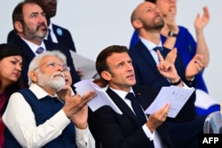 El primer ministro de la India, Narendra Modi (izquierda), y el presidente francés, Emmanuel Macron, asisten al desfile militar del Día de la Bastilla en la avenida de los Campos Elíseos en París el 14 de julio de 2023.