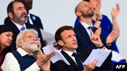 Perdana Menteri India Narendra Modi (kiri) dan Presiden Prancis Emmanuel Macron menghadiri parade militer Hari Bastille di jalan Champs-Elysees di Paris,14 Juli 2023. (Emmanuel DUNAND / AFP)